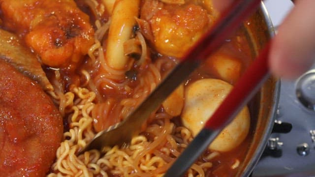 Appetizing tteokbokki with plenty of ingredients such as ramen and fish cake