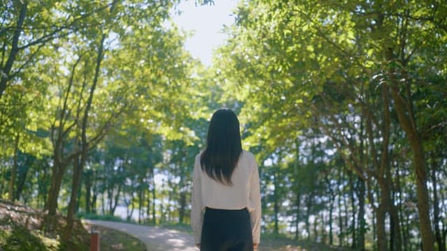 Woman Walking on a Forest Path