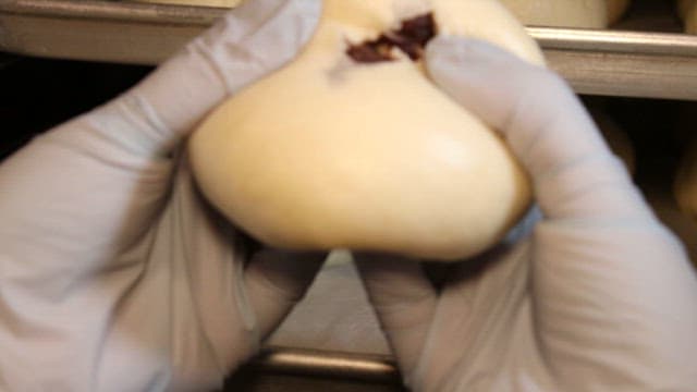 Cutting steaming bread in a bakery