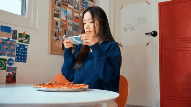 Woman taking photos of a pizza indoors