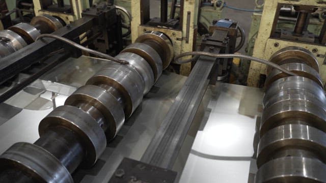 Metal rollers processing sheets in a factory