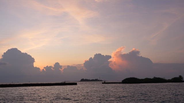 Serene sea with a boat at sunset