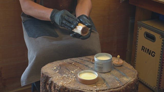 Craftsman polishing a wooden object indoors