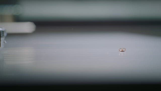 Hand Lifting an Earring Placed on a Table
