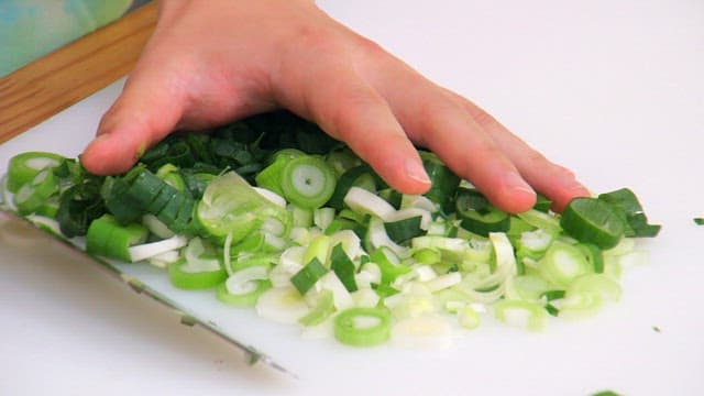 Chopping green onions and frying in a pan