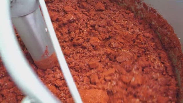 Mixing red spices in a large industrial container