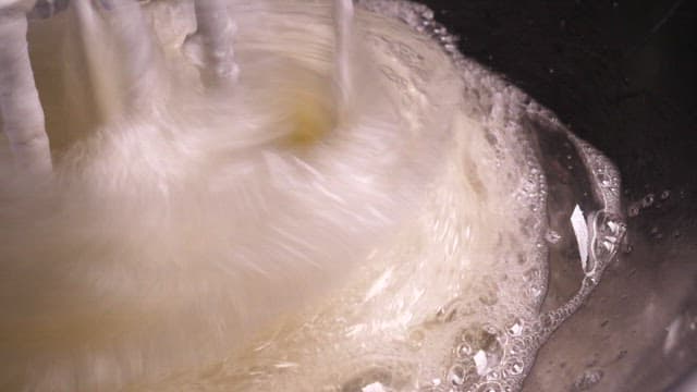 Whisk whipping and stirring in a metal bowl