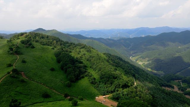 Lush green mountains under a cloudy sky