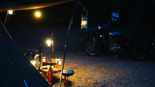 Campsite lit by lanterns in the dark evening