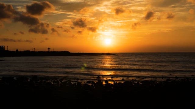 Serene Sunset over a Rocky Beach