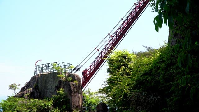 Hikers climbing the red, steep steps on a rocky mountain
