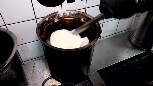Preparing Cheese in a Rustic Kitchen Pot