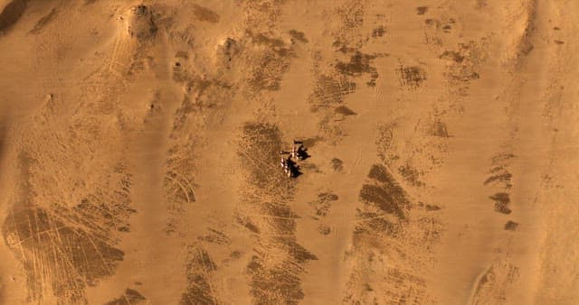 Camels and travelers in a vast desert
