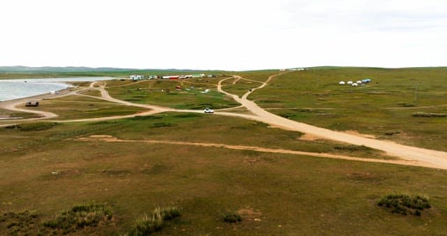 Car driving through a vast green landscape