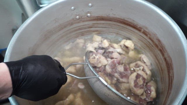 Oxtail boiled in a large cauldron in the restaurant kitchen
