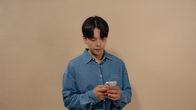 Man smiling while sending messages on his cell phone