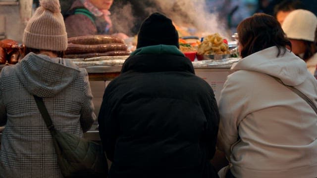 People enjoying street food at a traditional market