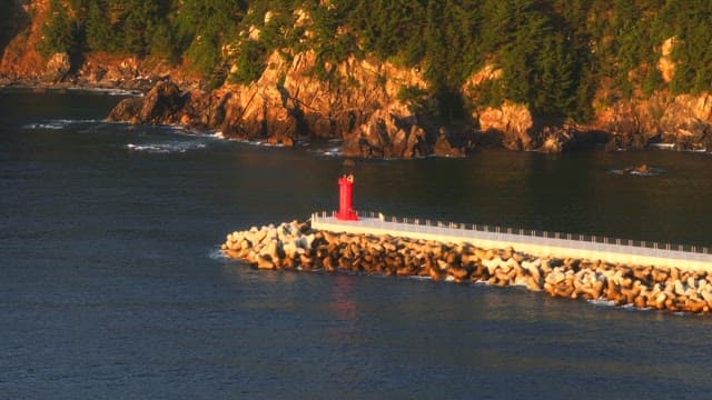 Red lighthouse on a rocky coastline