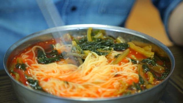 Stirring yeolmu noodles with chopsticks