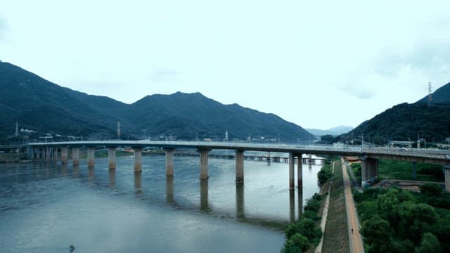 A bridge over a river with mountains