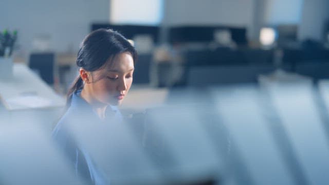 Woman makes coffee in the office and returns to her seat