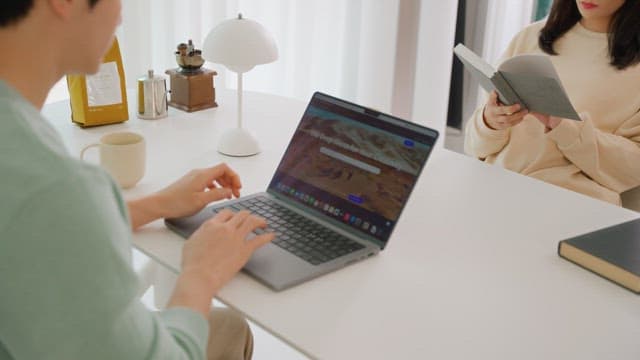 Two people enjoying leisure time at the white table in the living room