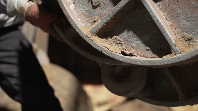 Worker handling heavy metal covers