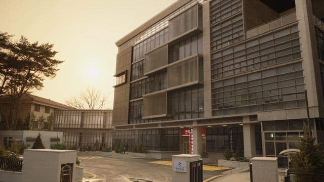 Modern building front with parking area at dusk