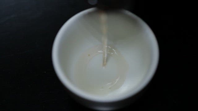 Tea being poured into a white cup