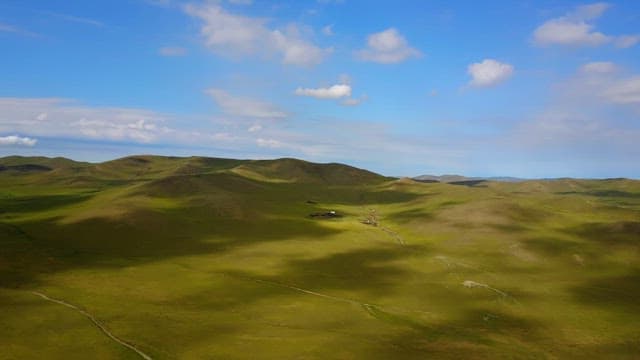Expansive green hills under a blue sky
