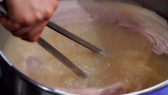 Scene of removing boiled pork with tongs
