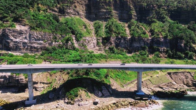 Coastal Highway Bridge Amidst Lush Cliffs
