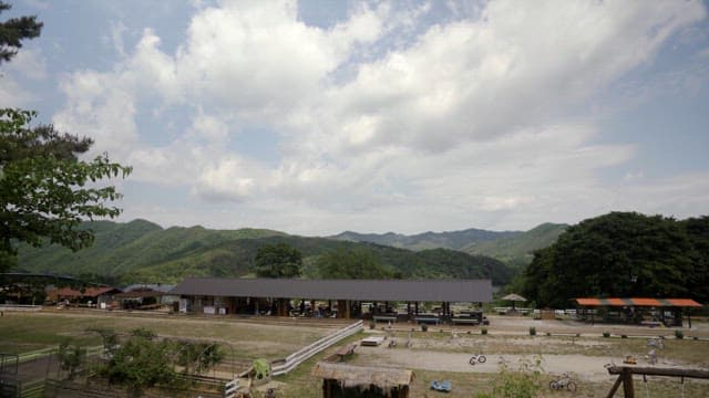 Serene Rural Landscape with Stable and Mountains