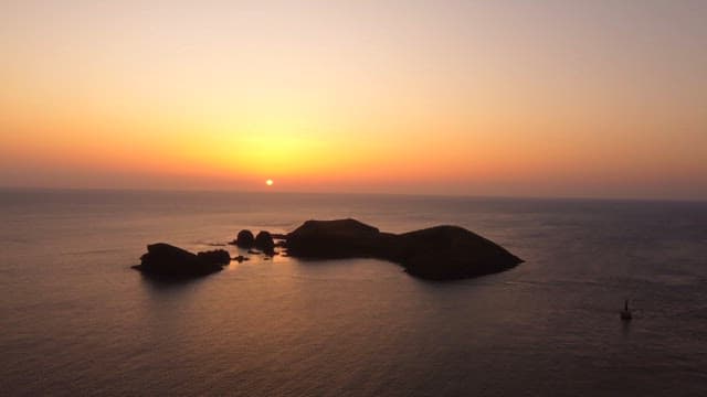 Sunset over a tranquil ocean with islands