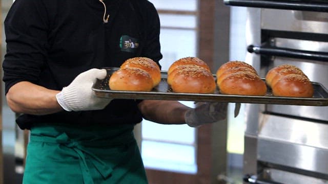 Freshly baked burger buns on a tray