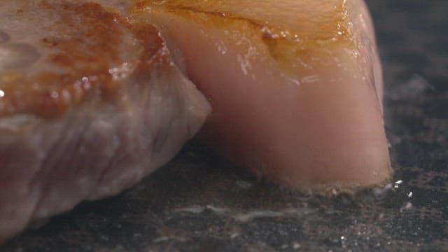 Pork belly sizzling on a hot pan