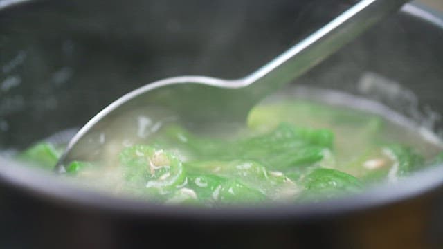 Steaming hot pepper soup in a black pot
