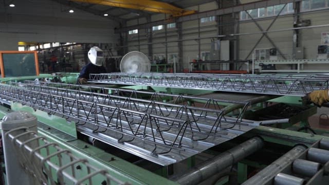 Workers assembling metal structures in a factory