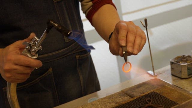 Artisan shaping a ring with a torch