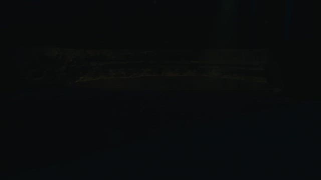 Man confined in a dark room decorated with candles