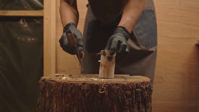 Person carving wood indoors