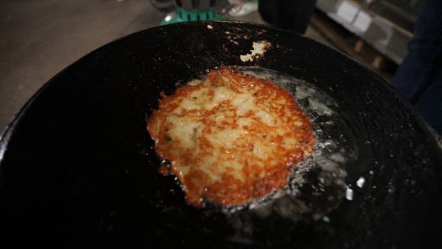Crispy pancake frying in oil on a hot skillet
