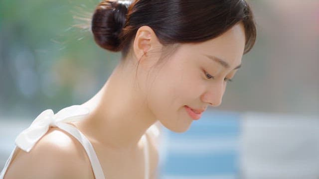 Woman smiling and tapping her lips in a bright room