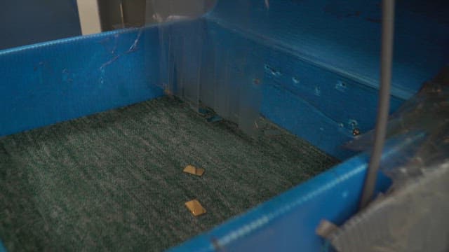 Small metal pieces in a blue container