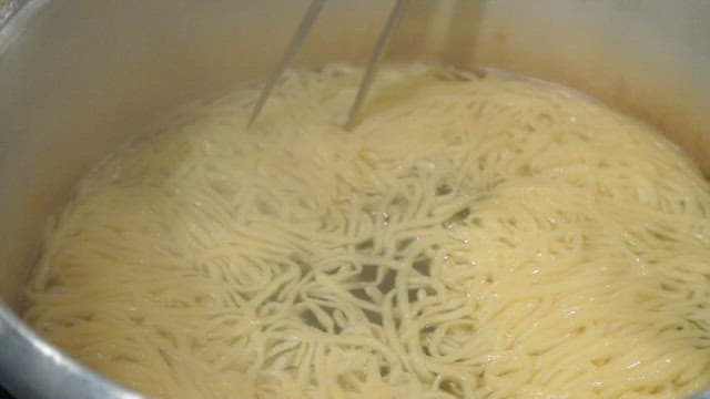 Noodles being cooked and strained