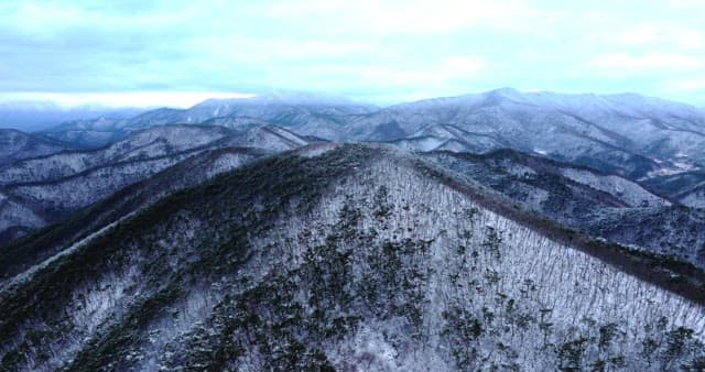 Snow-covered mountains under cloudy skies