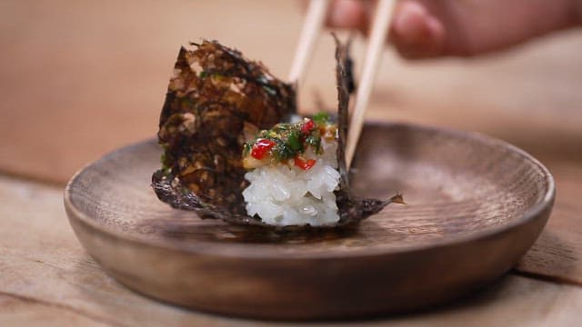 Wrapping rice in seaweed and lifting it with chopsticks