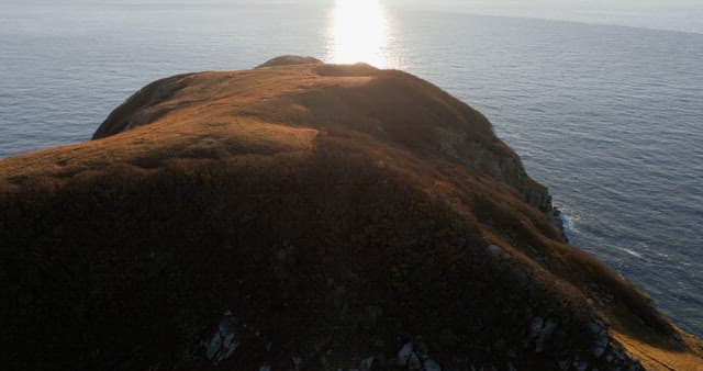 Serene Coastal Landsacape with Sun Reflecting on Water