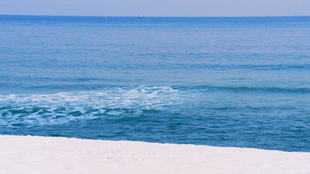 Calm ocean waves meeting a snowy beach
