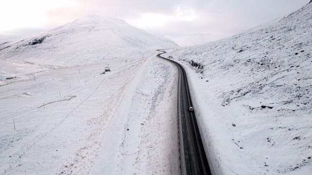 Car driving on a snowy mountain road